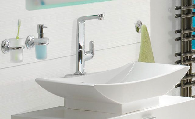 Fliesenserie KALMIT von Steuler Design | Bild: Panariagroup Deutschland GmbH Dunkle Strukturfliesen mit dreidimensionaler Oberfläche, daneben ein Waschtisch mit gelbem Handtuch und Waschbecken.